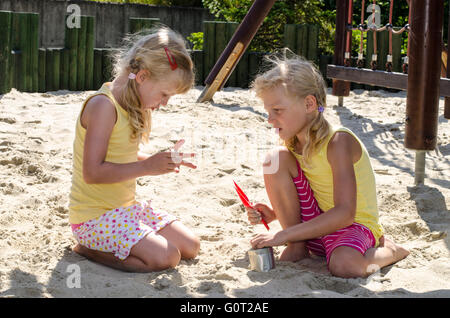 freundlichen Mädchen spielen im Sandkasten Stockfoto