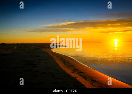 Sonnenuntergang über der Binnenschifffahrt Bucht Playa del Trabucadores, Tarragona, Spanien. Stockfoto