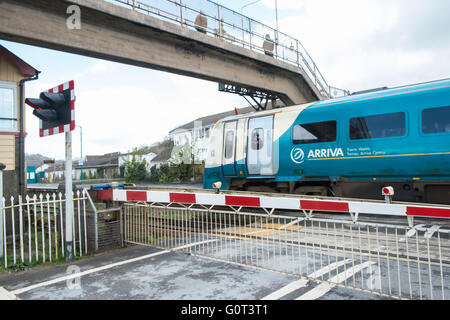 Arriva Zug vorbei Hindernis von einem Bahnübergang am Ferryside Bahnhof, Carmarthenshire, West Wales,U.K. Stockfoto