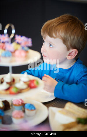 Kleiner Junge mit süßen Kuchen versucht Mann Männer männlich seine ihm He Jungs jungen Jungen Kids Kinder Jugendliche Kind Kleinkinder Adolescen Stockfoto