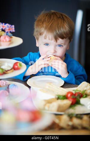 Kleiner Junge mit süßen Kuchen versucht Mann Männer männlich seine ihm He Jungs jungen Jungen Kids Kinder Jugendliche Kind Kleinkinder Adolescen Stockfoto