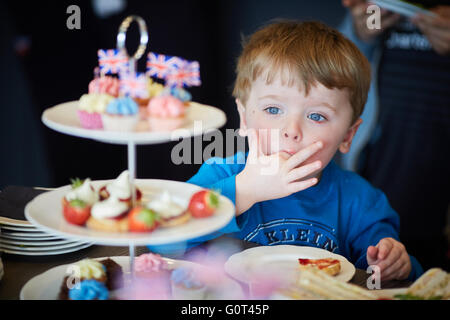 Kleiner Junge mit süßen Kuchen versucht Mann Männer männlich seine ihm He Jungs jungen Jungen Kids Kinder Jugendliche Kind Kleinkinder Adolescen Stockfoto