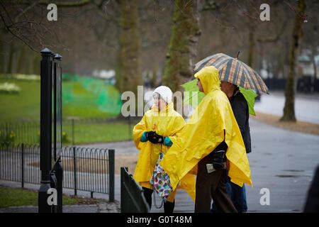 Touristen essen gelb Einweg Regen Mäntel Blätter Ponchos Regen nassen Wetter Kunststoff Regen Mantel Abdeckung bleiben trocken Stockfoto