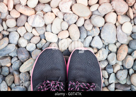 Laufschuhe im Hausgarten auf Kieselsteinen, Fotoarchiv Stockfoto