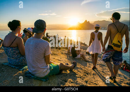 RIO DE JANEIRO - 26. Februar 2016: Massen von Menschen versammeln, um den Sonnenuntergang auf den Felsen am Arpoador in eine beliebte Tradition. Stockfoto