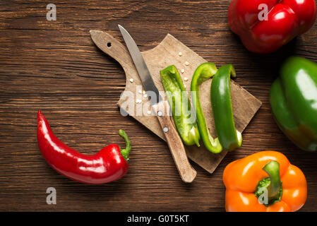 Rot, grün und orange Paprika auf hölzernen Hintergrund. Stockfoto