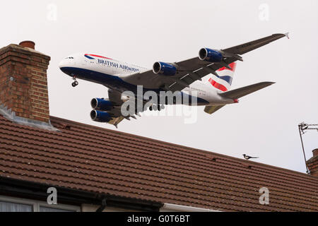 British Airways-Airbus A380 - 841 (G-XLEK) über Dächer am Flughafen London Heathrow landen. Stockfoto