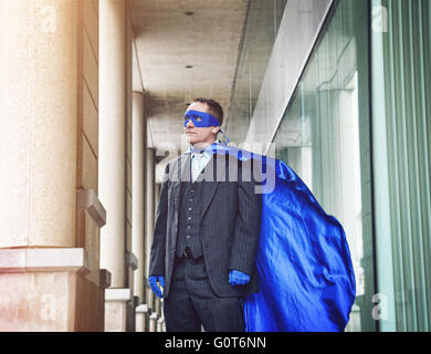 Ein super Business-Mann trägt einen blauen Umhang zuversichtlich in die Stadt für ein Erfolg, Unternehmer oder Inspiration Konzept. Stockfoto