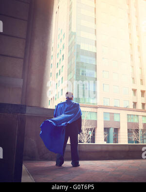 Ein Business-Mann trägt ein super Cape steht in einer Stadt für ein Erfolg, Stärke oder macht Karriere-Konzept. Stockfoto