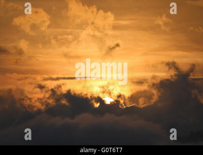 Teil-oder Sonne hinter die dunkle Wolke mit goldenen Himmel als Hintergrund angezeigt. Stockfoto