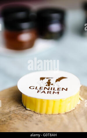 Ein Stück Glenilen Farm irischer Sahne Butter auf einem Brett aus Holz Brot mit Marmelade im Restaurant des Hotels. Stockfoto