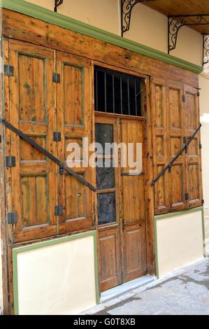 Tür mit zwei Holzfenster mit zwei Läden in Bogen von brauner Farbe. Stockfoto