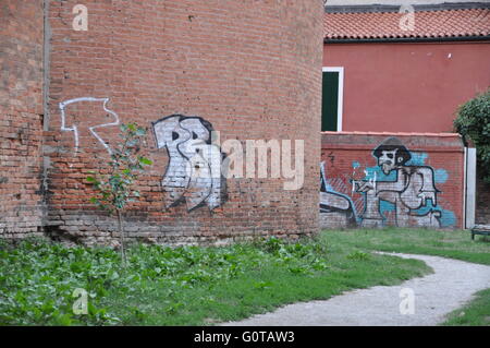 Graffiti auf Backstein-Gebäude-Fassade, Bild des Menschen auf der Mauer, Weg, Venedig, Italien, Sprühfarbe, Stockfoto