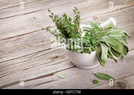 Frische Kräuter aus dem Garten in Mörtel auf Holztisch. Oregano, Thymian, Salbei und Rosmarin. Zeigen mit textfreiraum an Stockfoto