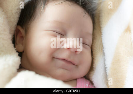 Porträt von einem Lächeln neugeborenes Mädchen schlafen Stockfoto