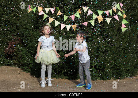 Jungen und Mädchen auf einer Gartenparty feiern Stockfoto