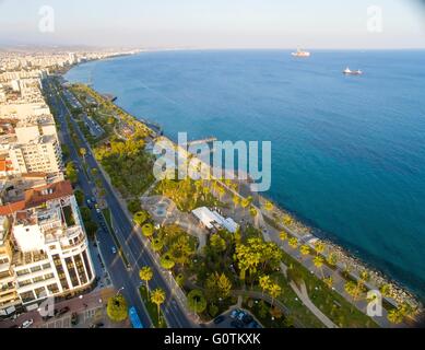 Luftaufnahme von Molos Promenade an der Küste von Limassol Stadt in Zypern. Ein Blick auf den Spaziergang Pfad, umgeben von Palmen, pools Stockfoto