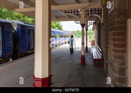 Einsame Frau auf einer Bahn Bahnhof Plattform, Derbyshire, England, UK Stockfoto