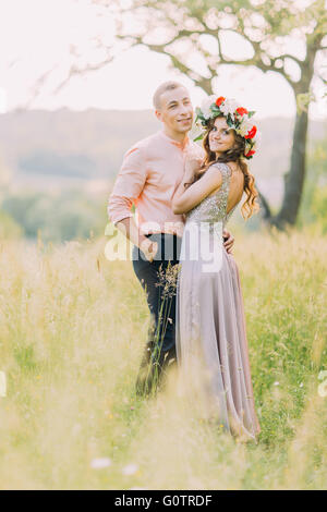 Porträt schön Frühjahr junge Liebespaar umarmt im blühenden Garten Stockfoto