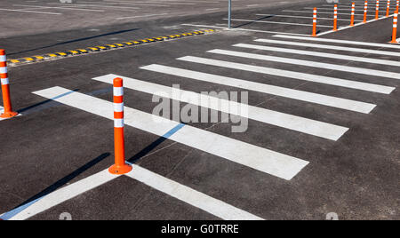 Weisse Abzeichen Verkehr mit einem Fußgängerüberweg auf einem grauen Asphalt-Parkplatz Stockfoto