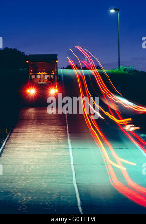 Lastwagen unterwegs auf Straße in der Nacht verlassen Streifen von bunten Lichtern Stockfoto