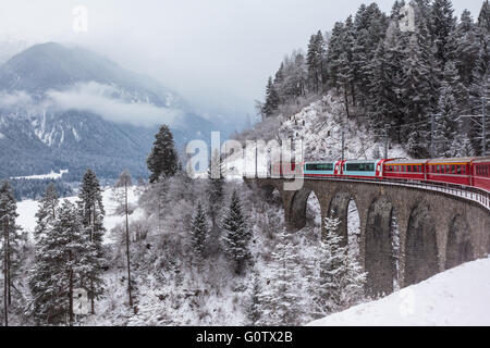 Sehenswürdigkeiten-Zug überfahren Viadukt in der Schweiz, dem Glacier-Express im winter Stockfoto