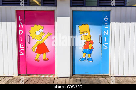 Cartoon Charaktere Bart und Lisa Simpson dargestellt an der Tür von einer öffentlichen Toilette am Central Pier in Blackpool, Lancashire, UK Stockfoto