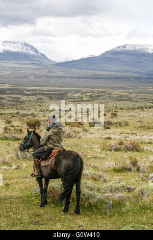 Gaucho auf seinem Pferd mit Blick auf die fernen Berge, Patagonien Stockfoto