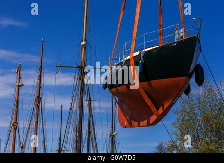 Greifswald, Deutschland. 4. Mai 2016. Ein Historiocal Nboat wird in das Wasser in der Museum-Werft in Greifswald nach der Winterpause in Greifswald, Deutschland, 4. Mai 2016 abgesenkt wird. Insgesamt 16 historische Segler Boote mit einem Gewicht von 400 kg bis 30 Tonnen werden in das Ostsee-Wasser mit einem mobilen Kran nach ihrer Winterpause aufgehoben. Die meisten der traditionellen Segelschiffe werden Fahrten auf der Ostsee oder dem Bodden Gewässern in den nächsten Tagen machen. Foto: JENS Büttner/Dpa/Alamy Live News Stockfoto