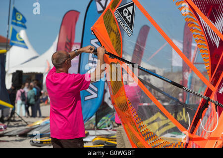 Fehmarn, Deutschland. 5. Mai 2016. Ein Mann bereitet seine Windsurfer für das Segeln an der Küste der Ostsee in Fehmarn, Deutschland, 5. Mai 2016. Auf der Insel Fehmarn ist ein Surf-Festival jetzt im Gange. Foto: AXEL HEIMKEN/DPA/Alamy Live-Nachrichten Stockfoto