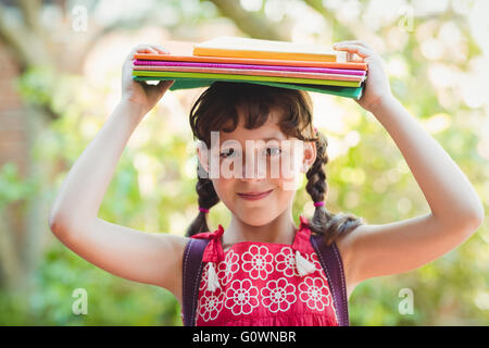 Brünette Mädchen mit Büchern über ihre Köpfe Stockfoto