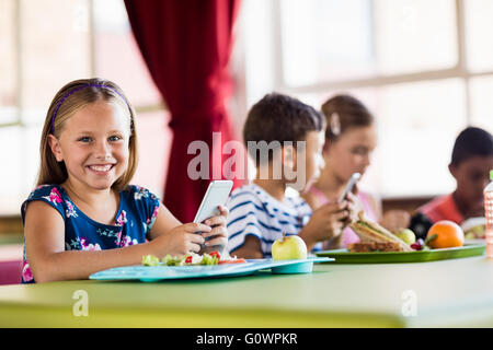 Kinder bei der Nutzung von Technologie in der Mittagspause Stockfoto
