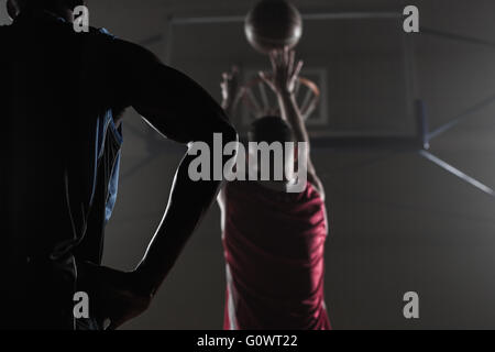 Rückansicht eines Spielers schießen einen basketball Stockfoto