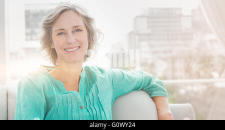 Entspannen Sie sich auf ihrer Couch glückliche Frau Stockfoto
