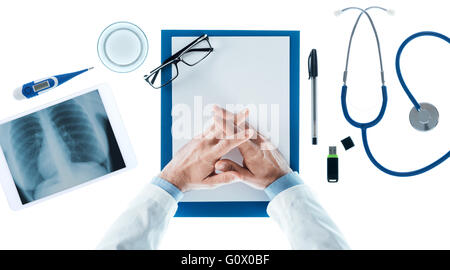 Arzt mit den Händen umklammert warten am Schalter auf weißem Hintergrund, Draufsicht, Gesundheit und Prävention-Konzept Stockfoto