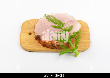 Stapel von Schinkenscheiben und Dill auf Holzbrett Stockfoto