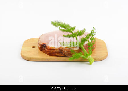 Stapel von Schinkenscheiben und Dill auf Holzbrett Stockfoto