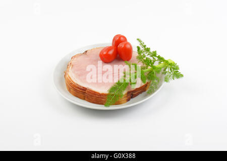 Stapel von Schinkenscheiben, Cherry-Tomaten und Dill auf weißen Teller Stockfoto