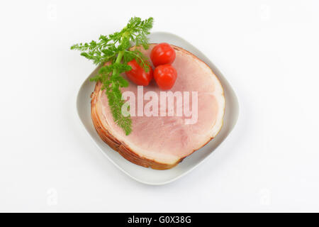 Stapel von Schinkenscheiben, Cherry-Tomaten und Dill auf weißen Teller Stockfoto