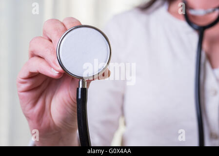 Ärztin ist Stethoskop in die Kamera halten. Stockfoto