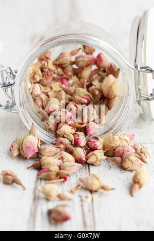 Getrocknete Rosenknospen verschütten aus einem Glas Stockfoto