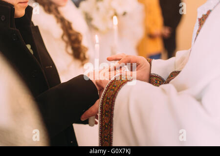 Der Priester Kleider einen Ring am Finger, während kirchliche Hochzeit Bräutigam Stockfoto