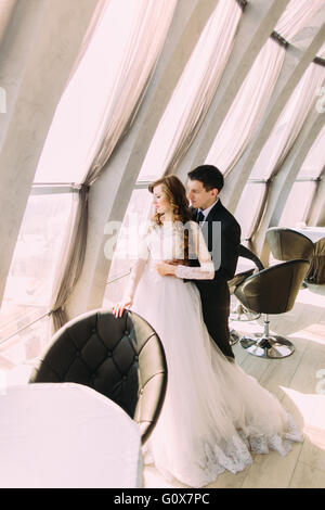 Nur verheiratete Paare umarmen in der Nähe von großen Fenstern im luxuriösen restaurant Stockfoto