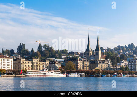 Blick auf Vierwaldstättersee auf der Seeseite, die berühmte Kirche St. Leodegar, an einem sonnigen Sommertag mit Wolken und blauer Himmel, in der Schweiz Stockfoto