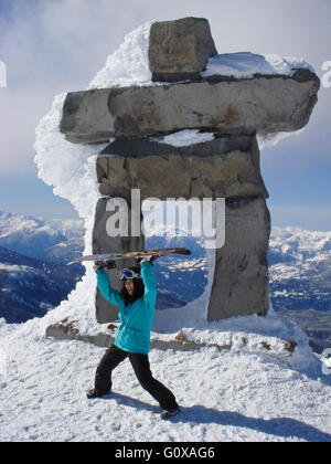 Snowboarder vor Ilanaaq, das Maskottchen Inuksuk von den Olympischen Winterspielen 2010, Whistler Blackcomb Resort, BC, Kanada. Stockfoto