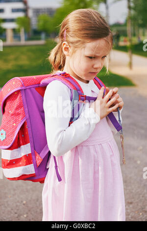 Porträt von 5 jährige Schülerin mit ihrem rosa und lila Schultasche, Tagträumen Stockfoto