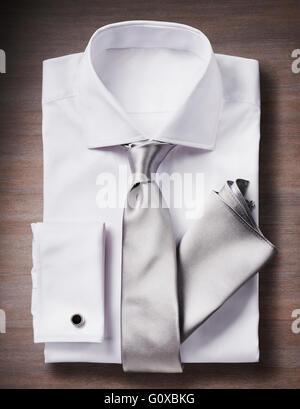 Weißes Hemd mit Krawatte, Taschentuch und Manschettenknöpfe, Studio gedreht auf hölzernen Hintergrund Stockfoto