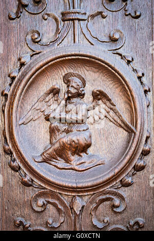 Engel eingraviert auf dem hölzernen Portal einer mittelalterlichen Kirche. Stockfoto