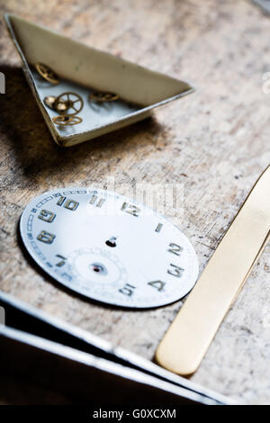 Werkzeuge-Quadranten und Uhrwerk auf einem Holztisch in einem Uhrmacher-shop Stockfoto