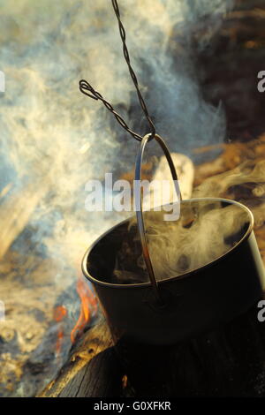 Eine große Edelstahl Topf zu Kochen gebracht zum Kochen in ein offenes Lagerfeuer in Queensland, Australien. Stockfoto